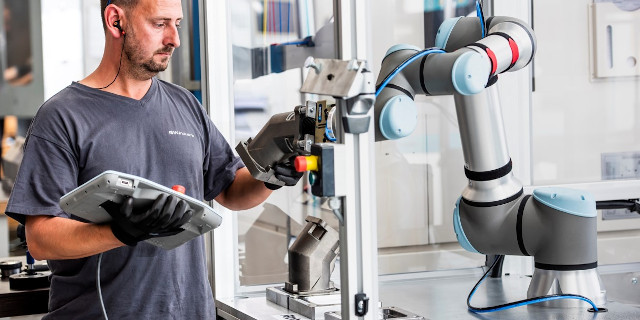 Imagen de un operario con un brazo de Universal Robots